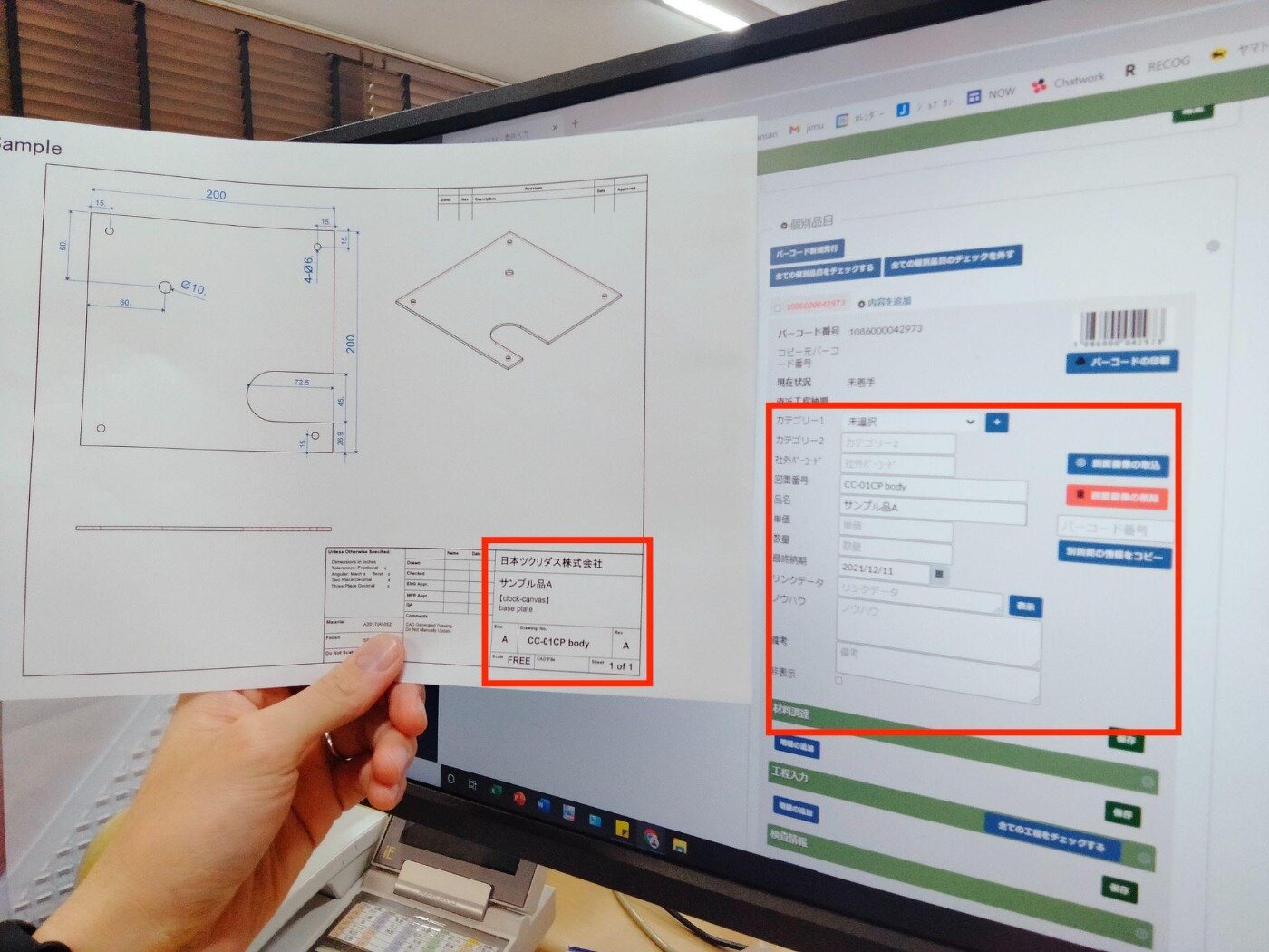 紙の図面を確認しながら、エムネットくらうどの個別品目登録画面に取引先や納期などの情報を入力する様子